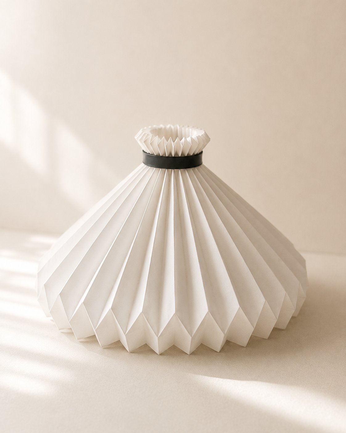 Wide pleated cone-shaped table lamp with a black ring collar