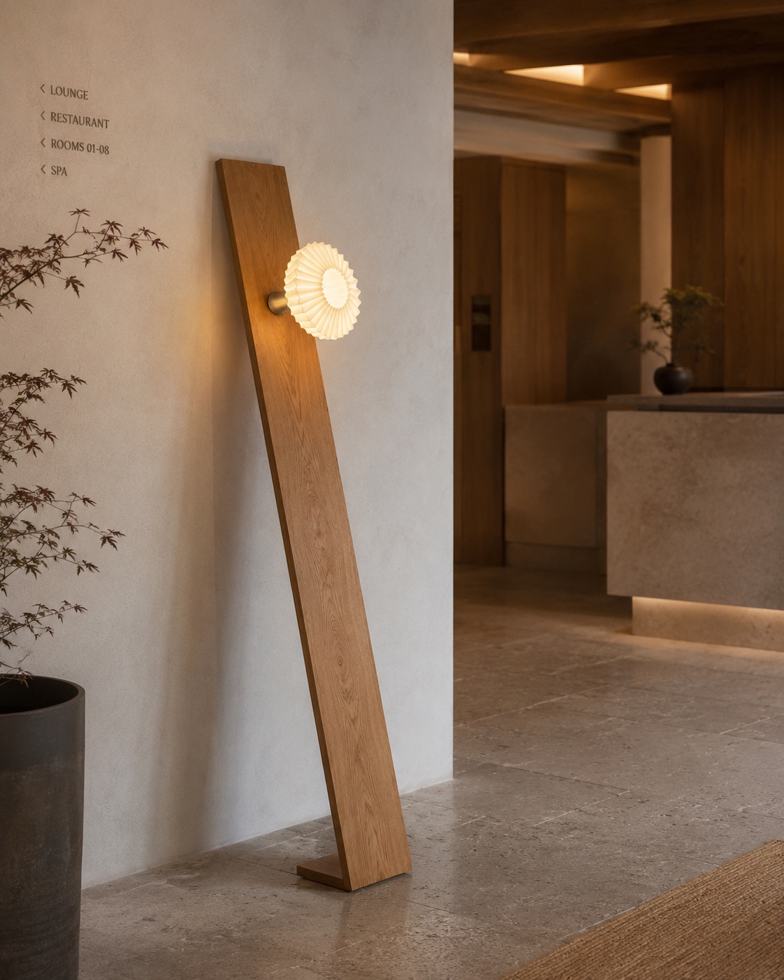 Leaning oak panel floor lamp with a round pleated shade, in a lobby